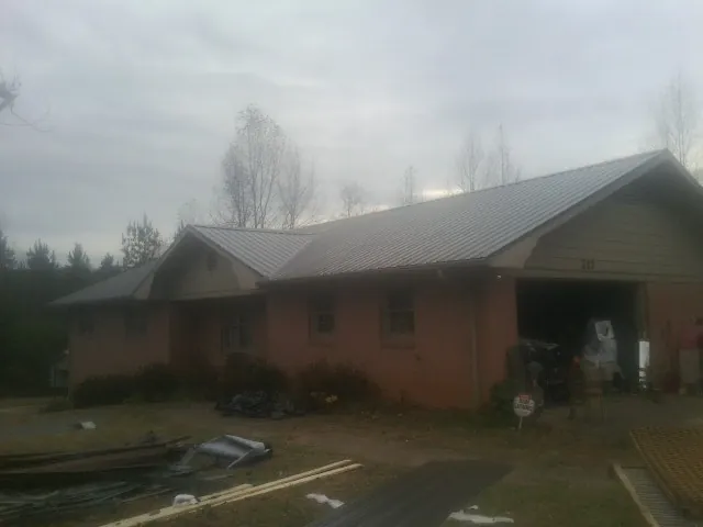 Gray metal roof on a stucco house with an attached garage in Williamsburg